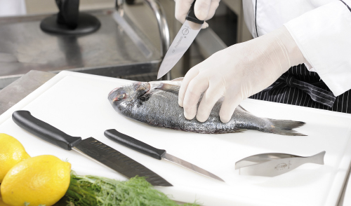 CHEF IN KITCHEN CUTTING FISH