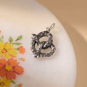 Sterling Silver Pretzel Charm on white plate edge