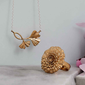 Bronze Ginkgo Necklace and Bronze Marigold Ring on blue background