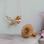 Bronze Ginkgo Necklace and Bronze Marigold Ring on blue background
