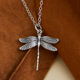 Sterling Silver Dragonfly Necklace on brown background