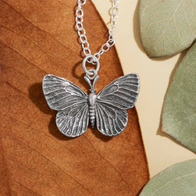 Sterling Silver Dimensional Butterfly Necklace on orange background