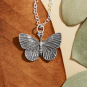 Sterling Silver Dimensional Butterfly Necklace on orange background