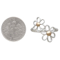 Mixed Metal Openwork Daisies Ring next to dime