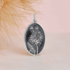 Sterling Silver Oval Dandelion Charm on pink background