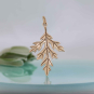Bronze Mugwort Leaf Charm on blue background