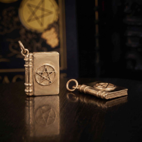 Bronze Magic Spell Book Charm on dark background