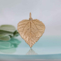 Bronze Aspen Leaf Charm on blue background