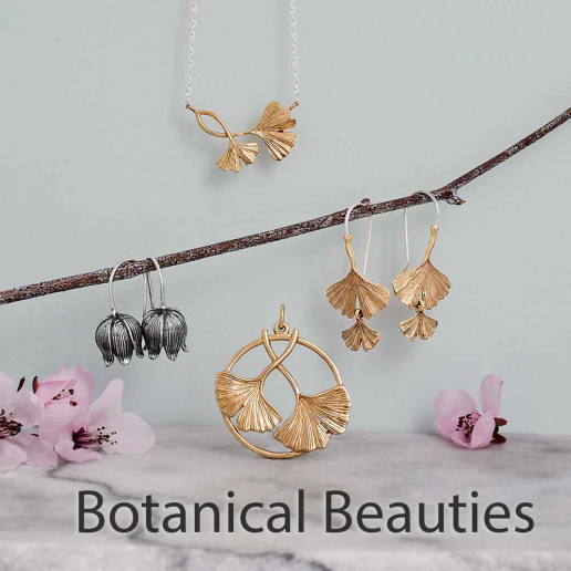 Bronze ginkgo jewelry and silver earrings on blue background