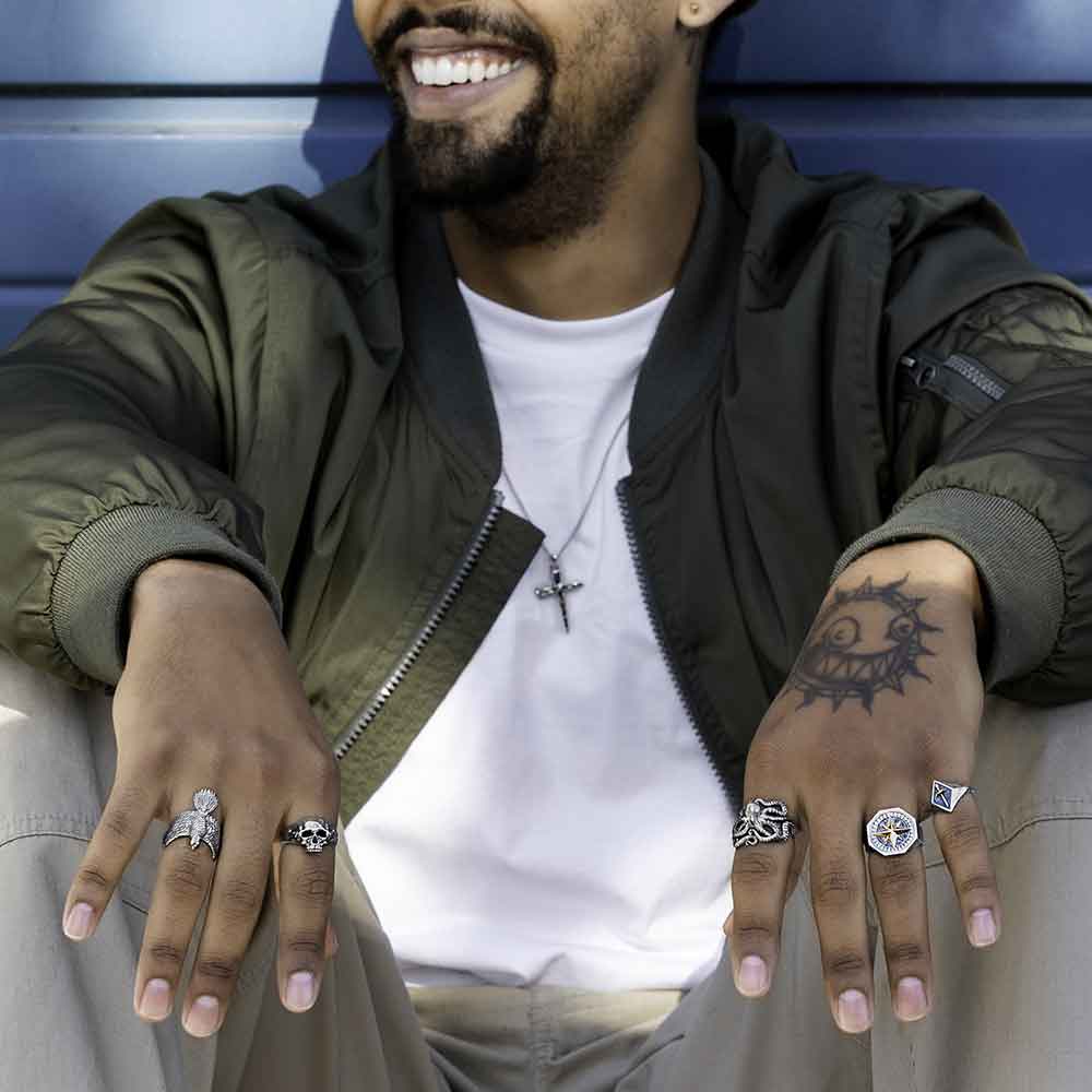 Man wearing sterling silver rings smiling on blue background