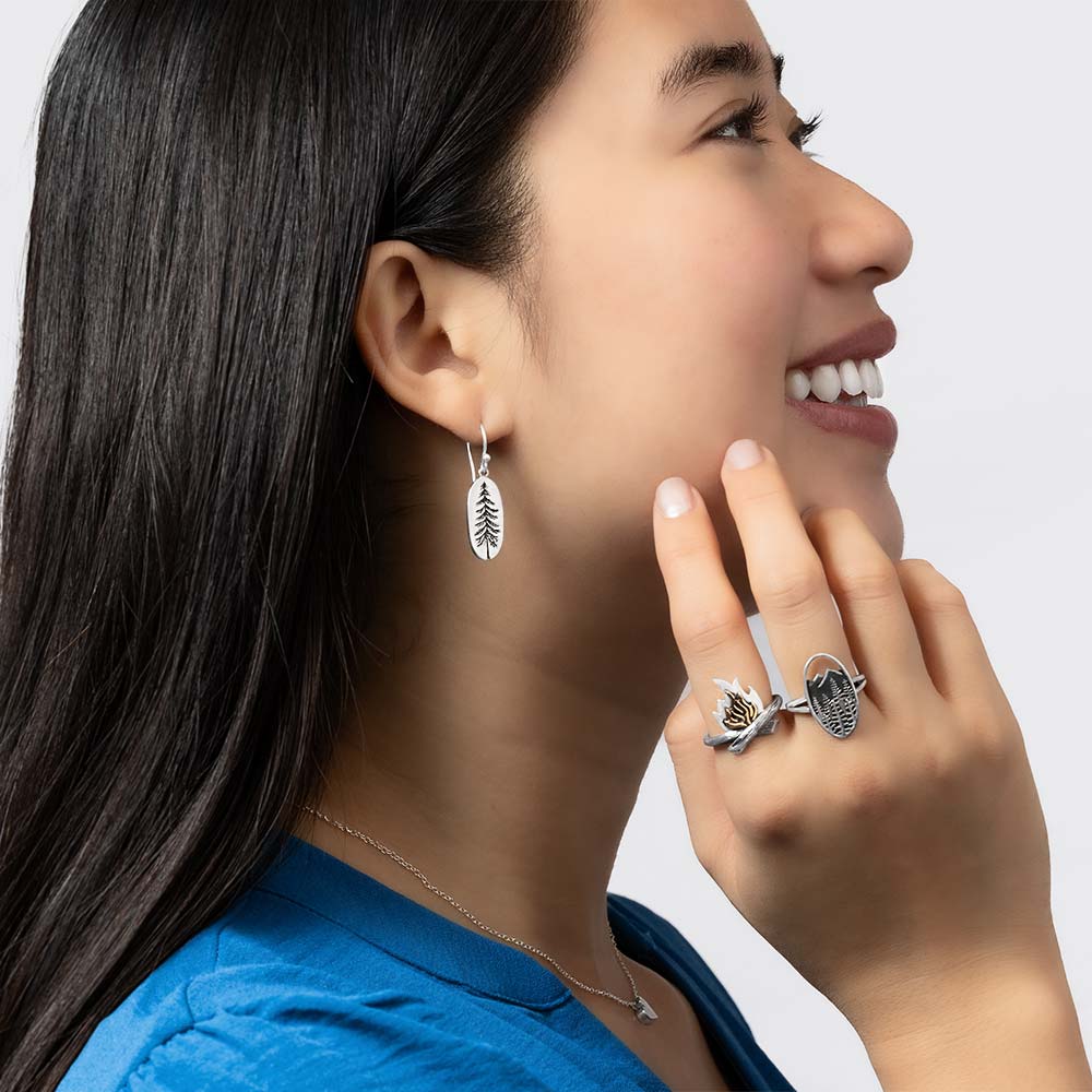Model wearing silver earrings and rings