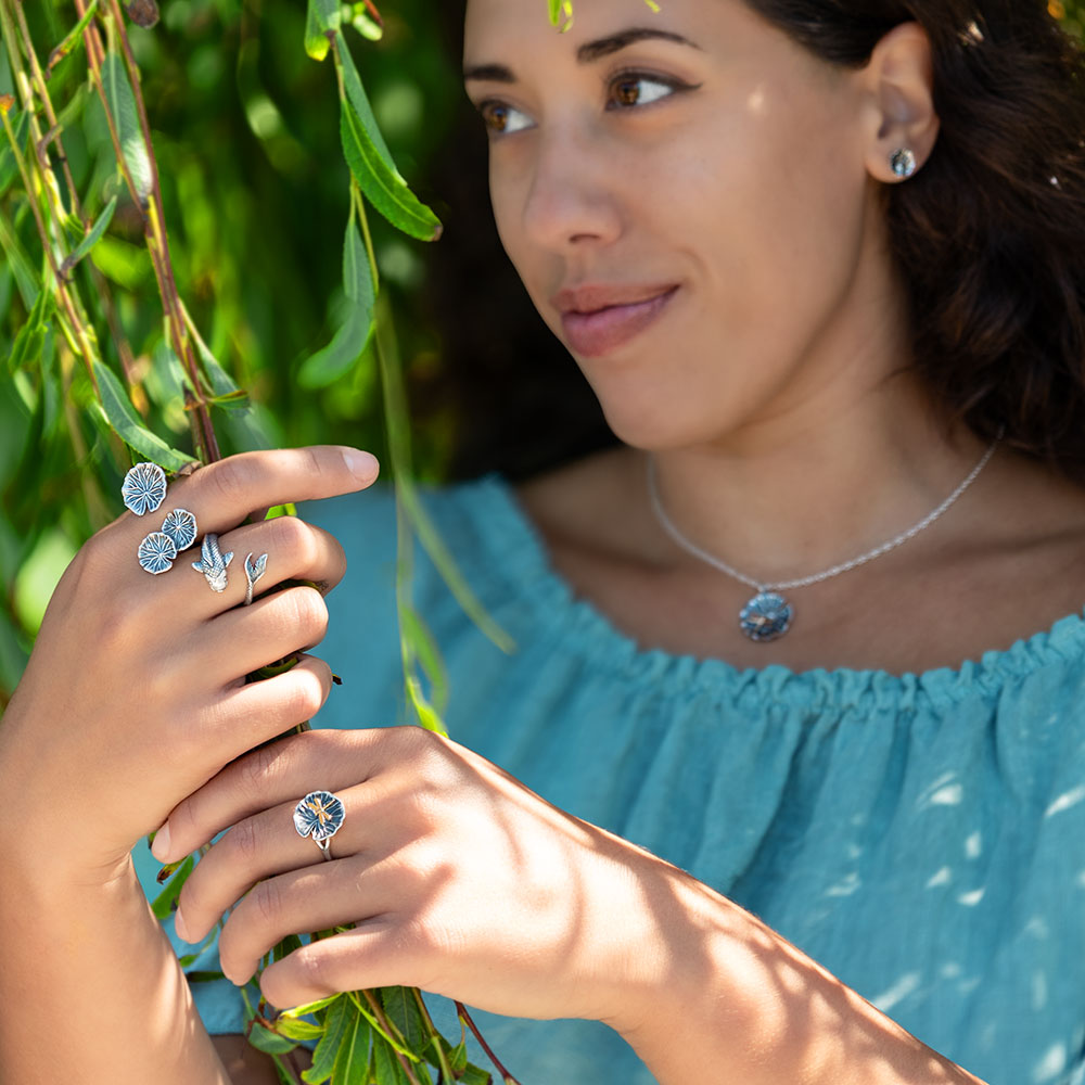 Woman standing in willow tree with silver jewelry on hands