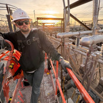 Benchmark FR Hooded Sweatshirt - Lifestyle - Man standing in oil field gazing into the eyes of the camera man