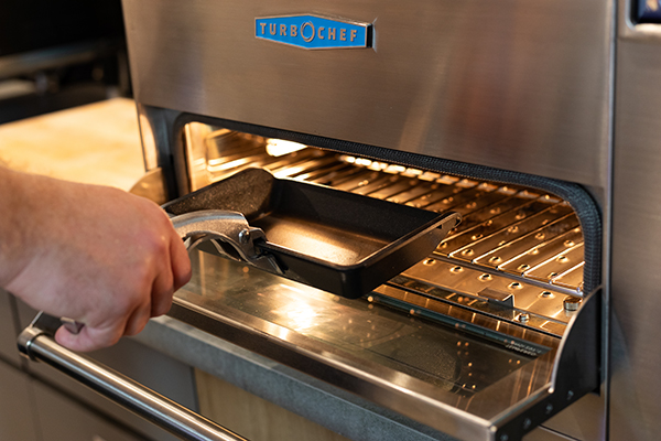 AMT cookware being placed inside of a speed oven