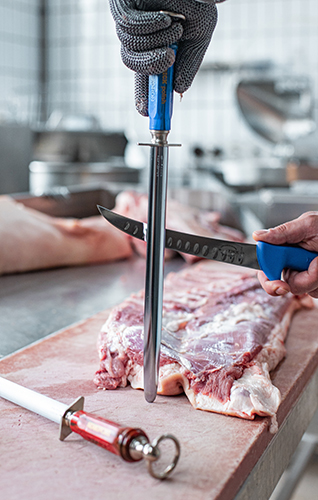FDick butcher holding a knife and sharpening steel